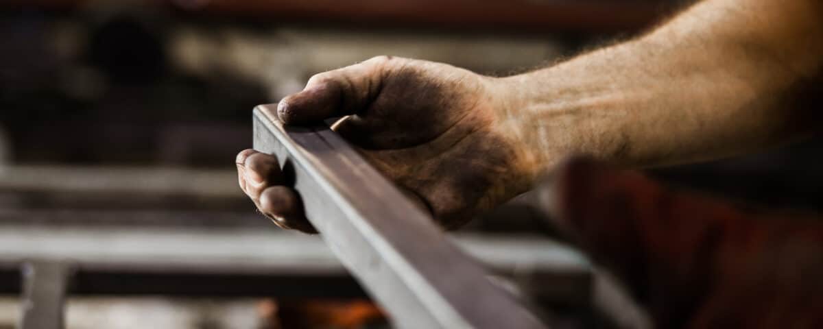 Close up of unrecognizable worker working with iron.